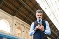 Mature businessman with smartphone on a train station. Royalty Free Stock Photo