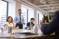 Mature Businessman Standing Giving Presentation To Colleagues In Modern Open Plan Office Royalty Free Stock Photo