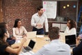 Mature Businessman Standing And Leading Office Meeting Around Table Royalty Free Stock Photo