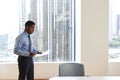 Mature Businessman Standing Rehearsing Before Giving Presentation In Modern Open Plan Office