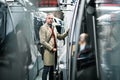 Mature businessman with suitcase travelling by subway in city.