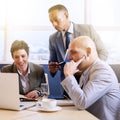 Mature businessman supervising his employees as they work Royalty Free Stock Photo