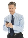 Mature Businessman Text Messaging Through Mobile Phone