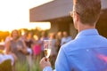 Mature businessman toasting wineglass with colleagues during success party on rooftop