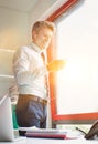 Mature businessman using smartphone with earphones on in office Royalty Free Stock Photo