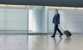 Mature businessman walking with his suitcase in the airport Royalty Free Stock Photo