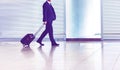 Mature businessman walking with his suitcase in the airport Royalty Free Stock Photo