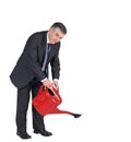 Mature businessman watering with red can