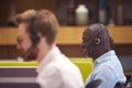 Mature Businessman Wearing Phone Headset Talking To Caller In Busy Customer Services Centre Royalty Free Stock Photo