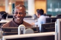 Mature Businessman Wearing Telephone Headset Talking To Caller In Customer Services Department Royalty Free Stock Photo