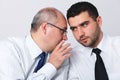 Mature businessman whisper something to colleague Royalty Free Stock Photo