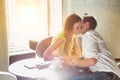 Mature businessman whispering on attractive woman ear while sitting in coffee shop Royalty Free Stock Photo