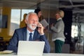 Mature businessman working on laptop. Handsome mature business leader sitting in a modern office Royalty Free Stock Photo