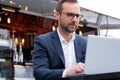 Mature Businessman Working On Laptop By Outdoor Coffee Shop Royalty Free Stock Photo