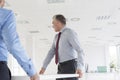 Mature businessmen carrying desk in new office