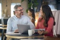 Mature Businesswoman And Businessman Working On Laptop In Informal Seating Area Of Modern Office Royalty Free Stock Photo