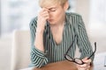 Mature Businesswoman Having Eyestrain Headache Massaging Nosebridge At Workplace Royalty Free Stock Photo