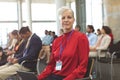 Mature businesswoman with laptop looking at camera during seminar Royalty Free Stock Photo