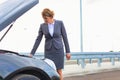 Mature businesswoman looking at breakdown car on road Royalty Free Stock Photo