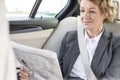 Mature businesswoman reading newspaper while sitting in car Royalty Free Stock Photo