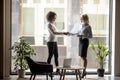 Mature businesswoman shaking hand of African American business partner