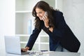 Mature Businesswoman Talking On Phone Working On Laptop In Office Royalty Free Stock Photo