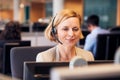 Mature Businesswoman Wearing Telephone Headset Talking To Caller In Customer Services Department Royalty Free Stock Photo