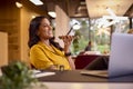 Mature Businesswoman Working On Laptop At Desk In Office Talking Into Mic Of Mobile Phone Royalty Free Stock Photo