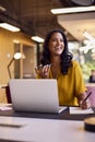 Mature Businesswoman Working On Laptop At Desk In Office Talking Into Mic Of Mobile Phone Royalty Free Stock Photo