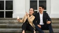 Mature businesswoman and young businessman talking each other, sitting on the stairs in front of business center Royalty Free Stock Photo