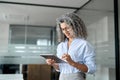 Smiling older professional business woman using tab computer in office. Royalty Free Stock Photo