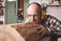 A mature carpenter cutting a piece of wood on a bandsaw Royalty Free Stock Photo