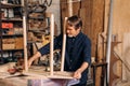 Mature carpenter measures the length of a table