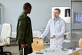 Doctor Inviting Soldier To Take Seat Royalty Free Stock Photo