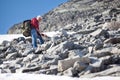 Mature Caucasian hiker climbing with backpack in steep slope mountain at summer season