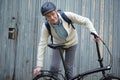 Man with a city bicycle against a gray gate doors Royalty Free Stock Photo