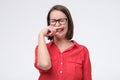 Mature caucasian woman in glasses closes her nose with hand Royalty Free Stock Photo