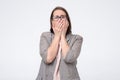 Mature caucasian woman with glasses covering her mouth in panic Royalty Free Stock Photo