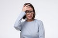 Mature caucasian woman has a terrible headache, isolated on white wall.