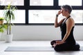 Mature Caucasian woman practicing yoga on livingroom floor Royalty Free Stock Photo