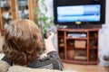 Mature Caucasian woman turning tv channels with remote control