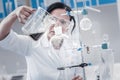 Mature chemist pouring liquid into separating funnel