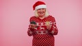 Mature Christmas grandmother woman use mobile cell phone, plastic credit bank card win calebrate wow
