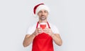 mature christmas man in red santa hat and apron holding coffee cup Royalty Free Stock Photo