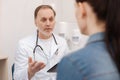 Mature competent doctor discussing something with his patient