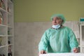Mature confident doctor standing in front of surgery room - focus on the face