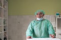 Mature confident doctor standing in front of surgery room - focus on the face
