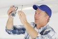 mature contractor installing cctv camera on ceiling