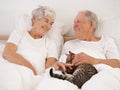 Mature couple, bed and cat for bonding, embrace and love in morning for smile and cuddle. Senior man, woman and kitty Royalty Free Stock Photo