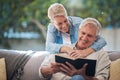 Mature couple, bond and funny book on house or home sofa in garden and backyard patio. Smile, happy or relax senior man Royalty Free Stock Photo